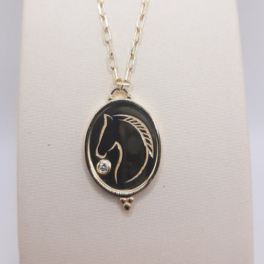 14Kt yellow gold equestrian necklace featuring a horse and .03 carat diamond on 22' paperclip chain