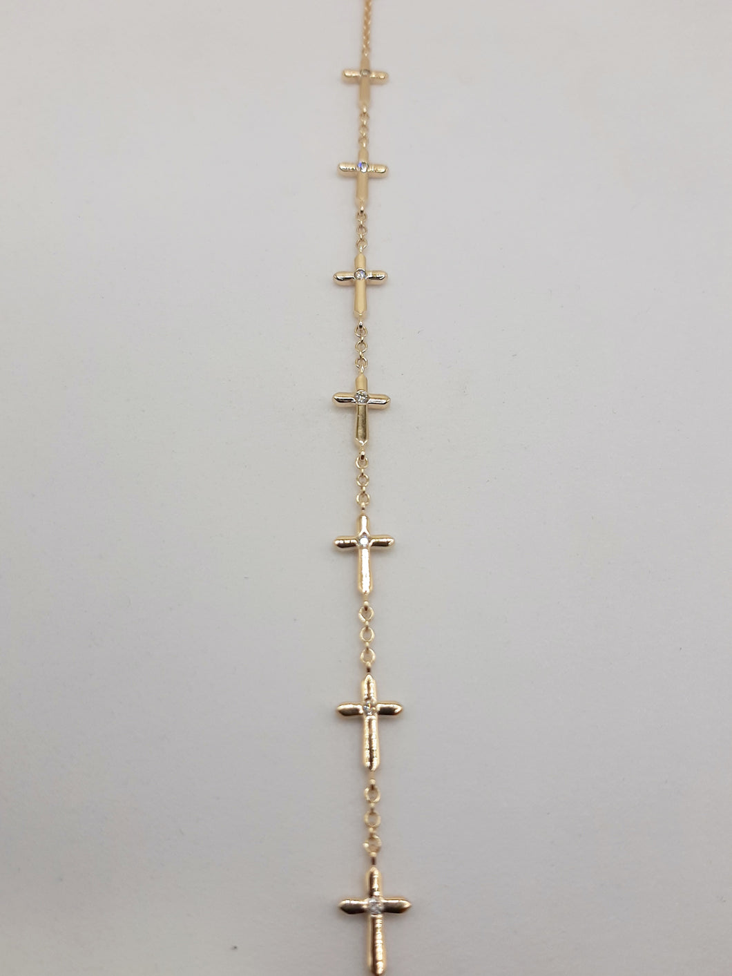 14kt yellow gold cross bracelet featuring .15 carats of natural diamonds