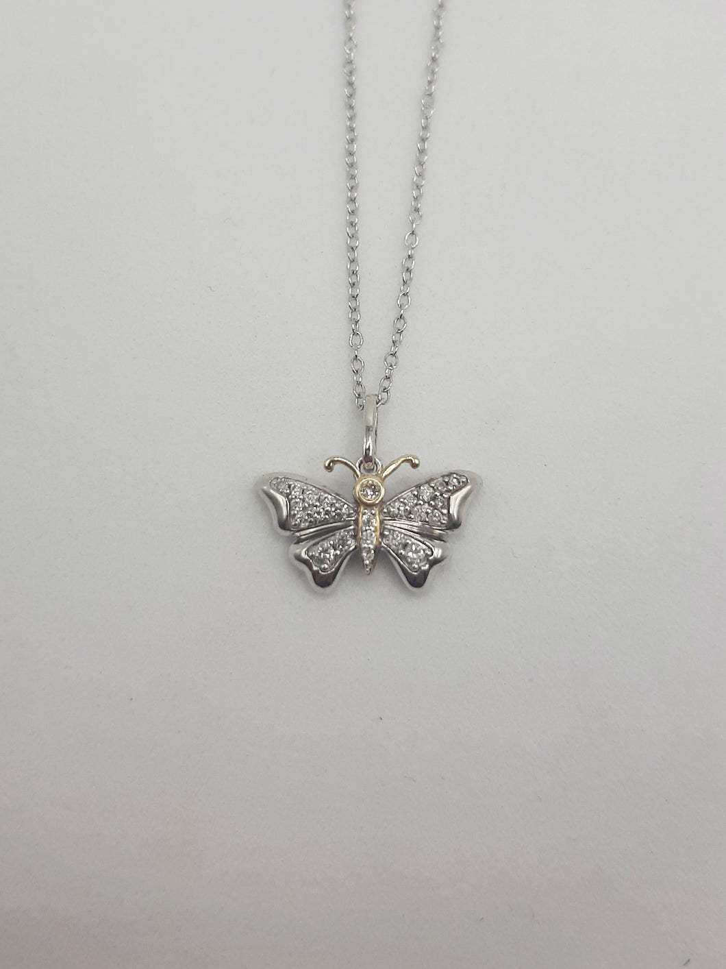 Sterling silver and 14kt yellow gold butterfly pendant featuring .20 carats of natural diamonds