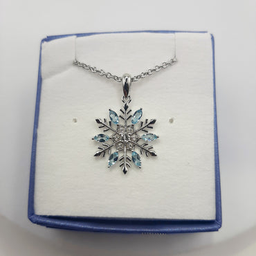 Sterling silver snowflake pendant featuring white and blue topaz