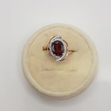 18kt rose gold featuring a 2.91 carat garnet and .19 carats of natural diamonds