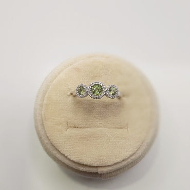 14kt white gold three stone ring featuring .53 carats of peridot and .12 carats of diamonds