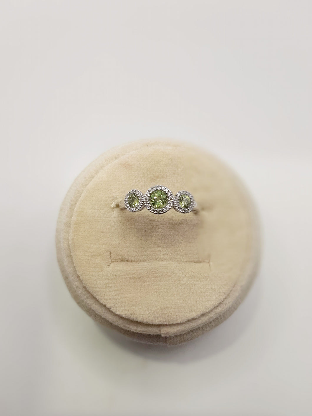 14kt white gold three stone ring featuring .53 carats of peridot and .12 carats of diamonds